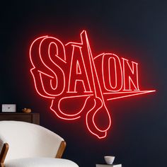 a neon sign that says savon on the side of a wall next to a chair