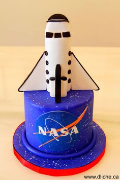 a cake made to look like a space shuttle on top of a nasa themed cake