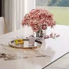 a dining room table with flowers and fruit on it