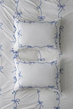 three white pillows with blue bows on them