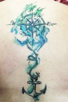 the back of a woman's shoulder with an anchor and compass tattoo on it