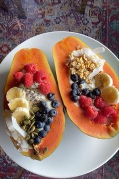 two halves of fruit are on a plate with granola and other food toppings