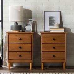 two wooden nightstands with pictures on top of them next to a lamp and window