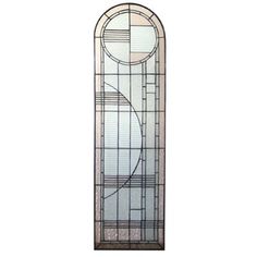 a tall stained glass window with a circular design on the top and bottom panel, against a white background