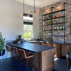 a modern kitchen with an island and bar seating in the center, surrounded by brick walls