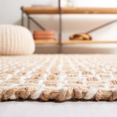 a close up view of a bed with white and brown blankets on top of it