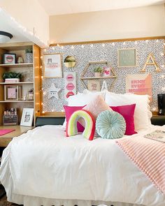 a bed with lots of pillows on top of it in a room filled with books