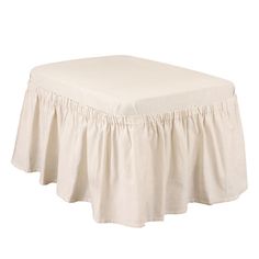 a white ottoman cover with ruffled edges