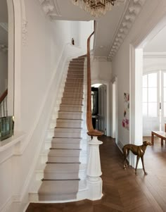 an elegant staircase with chandelier and wooden flooring