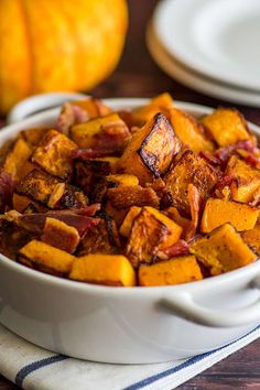 a white bowl filled with cooked food on top of a table