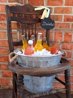 a bucket filled with drinks sitting on top of a wooden chair