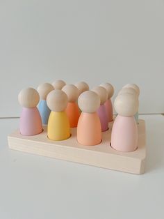 a group of small wooden toy figures sitting on top of a table next to each other