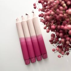 three pink and white candles sitting on top of a table