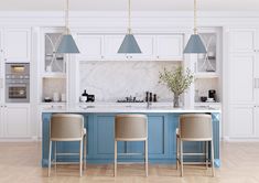 a kitchen with blue cabinets and white countertops, two bar stools in front of the island