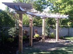 a wooden pergola in the middle of a yard