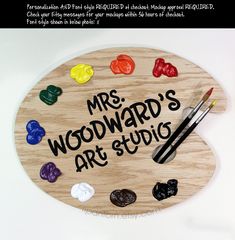 a wooden sign that says mr woodard's art studio with paint and brushes on it