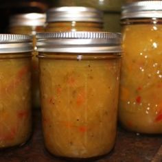 four jars filled with food sitting on top of a table