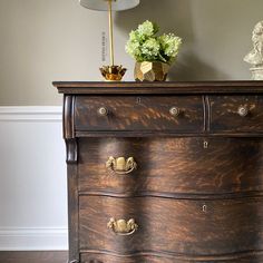 a wooden dresser with two drawers and a lamp on top