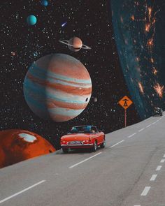 a red car driving down a road surrounded by planets