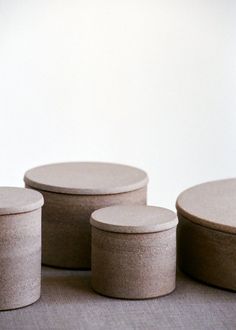 three round concrete containers sitting next to each other on top of a carpeted floor