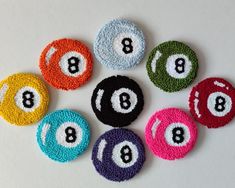 eight ball pool balls in different colors and sizes on a white surface with the number 8