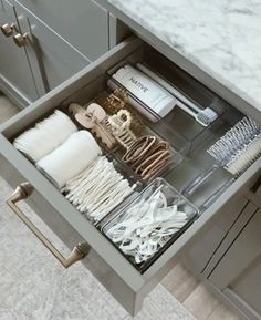 an open drawer in a kitchen filled with white utensils and other household items