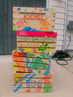 a stack of painted wooden blocks sitting on top of a cement floor next to a building