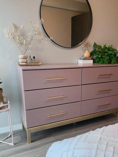 a pink dresser and mirror in a room