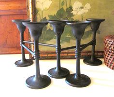 three black candlesticks sitting on top of a table