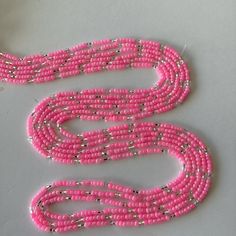 This uniquely and beautifully handcrafted. Women waist beads. Made with mixture of seeds and glass beads. Each strand is measured approximately 60 inches long.  Each purchase is 1 strand of waist bead of your choice  helps gets your waist snatched and beautifies your waist  Ready to ship. This is Tie on waist beads. Color of beads: Pink and silver. Size of beads 3mm. Materials used: beads/ friendly thread Multi-strand Beaded Waist Beads For Festival, Pink Spacer Beads For Festival, Pink Waist Beads With 108 Beads As A Gift, Adjustable Pink Waist Beads With Spacer Beads, Bohemian Beaded Chain Waist Beads, Pink Waist Beads For Festivals, Pink Festival Waist Beads, Pink Tiny Beads Waist Beads For Gift, Pink Bohemian Waist Beads With Colorful Beads