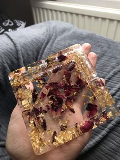 a person holding some kind of object in their hand with gold flakes on it