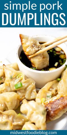 some dumplings are on a plate with chopsticks and sauce in the bowl