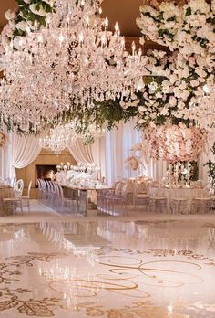 an elaborately decorated ballroom with chandeliers and floral centerpieces is shown