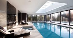 an indoor swimming pool with sun shining through the windows and glass doors on both sides