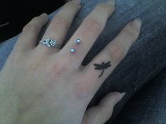 a person's hand with three different rings on it and one has a dragon tattoo