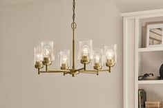 a chandelier hanging from the ceiling in a room with bookshelves and shelves