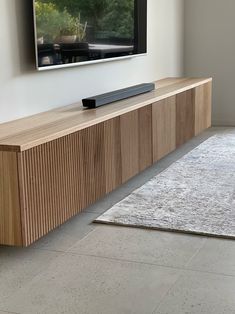 a flat screen tv mounted to the side of a wooden cabinet