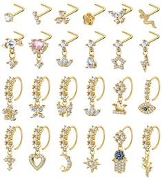 various types of ear rings with different designs and colors on them, all in gold