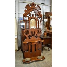 an old fashioned wooden cabinet with mirror on the front and side, next to other antique furniture