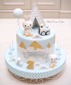 a blue cake with white frosting and some animals on the top is decorated like a tent