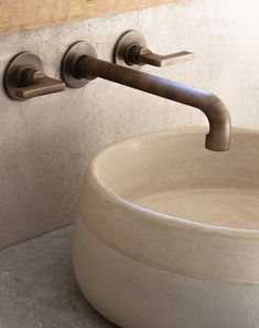 a bathroom sink with two faucets on the wall