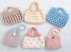 four crocheted purses sitting on top of a white table next to each other