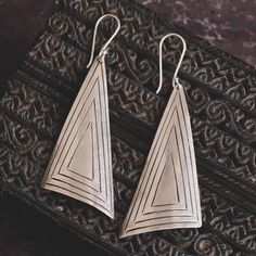 Inspired by tribal jewellery, these handmade large tribal triangle earrings feature an eye-catching, minimalist linear design. Made from high-content silver (97-98% Britannia quality silver as opposed to sterling which is 92.5% - the rest of the alloy is made from hypoallergenic metals such as copper and brass). * Sold as a PAIR * A high-quality, unique product * Ethically traded high-grade silver * Pair Weight 10gr * Gift boxed * Ships direct from Edinburgh, Scotland * Supports a small artisan Gold Vermeil Jewelry, Linear Design, Northern Thailand, Vermeil Jewelry, Triangle Earrings, Copper And Brass, Design Silver, Nature Jewelry, Family Business