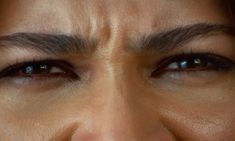 a woman's face with blue eyes and brown hair, close up shot from the bottom