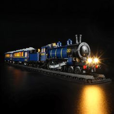 a toy train is lit up in the dark with its lights on and it appears to be ready for action