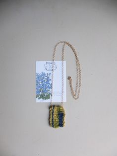 "These delicate and delightful all natural woven necklaces are inspired by botanical drawings of Dutch flowers found in a 1971 gardening book \"12 Months of Gardening\" passed down from my partner's grandfather. Every necklace is accompanied by the botanical illustration it is based on, as well as the fibers and materials used to make the piece. -Lobelia  Each tiny weave is completely unique even if the same floral illustration is used. All fibers used are natural yarns such Mohair, Wool, Cotton, Linen, Silk or Bamboo. The chain is Gold filled - A great quality mixture of 14k gold and bronze, that never tarnishes. The chain comes in two sizes: Long - 78 cm Short - 46cm These unique floral woven-art necklaces come in beautiful narrow grey linen boxes with the FynBosch logo and the info labe Lobelia Flowers, Dutch Flowers, Illustration Botanique, Woven Necklace, Art Necklaces, Fiber Jewelry, Necklace Delicate, Floral Illustration, Mohair Wool