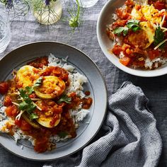 two bowls filled with food on top of a table