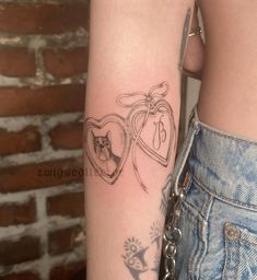 a woman's arm with two hearts and a cat in the middle on it