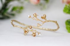 two pairs of gold plated earrings with flowers and pearls on the ends, sitting next to each other