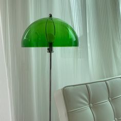 a green lamp sitting on top of a white couch